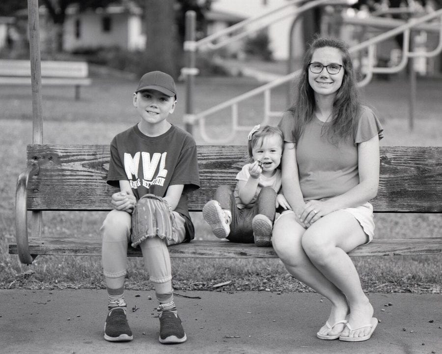 Family on a porch swing in black and white