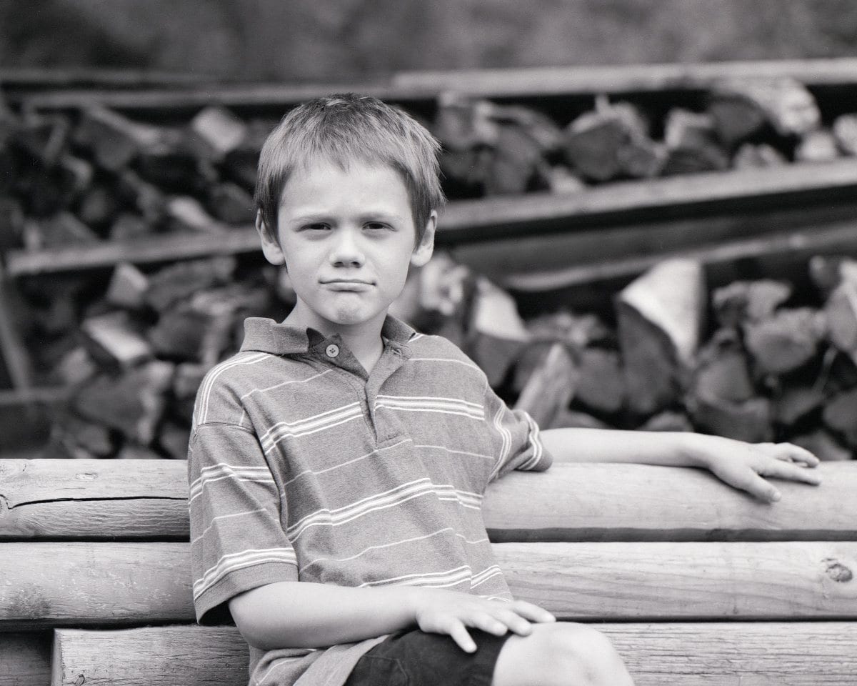 Boy seated beneath a tree, medium format film