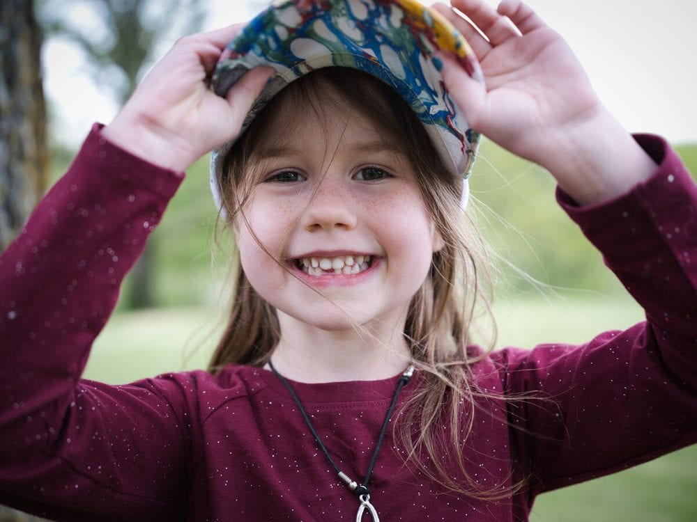 Child in a knit hat laughing
