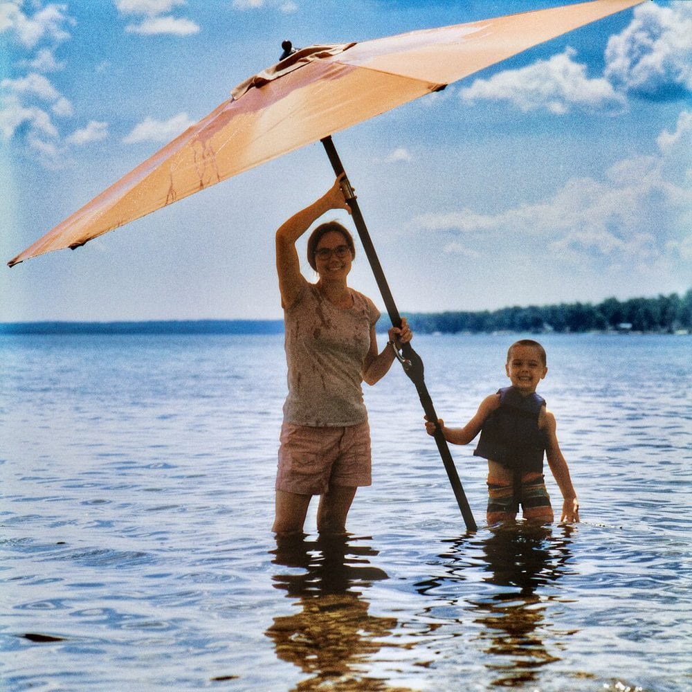 Mother and child wading with an umbrella